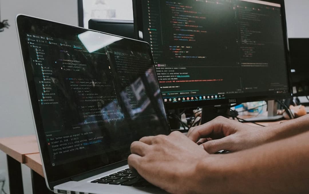 Developer working at workspace with multiple monitors
